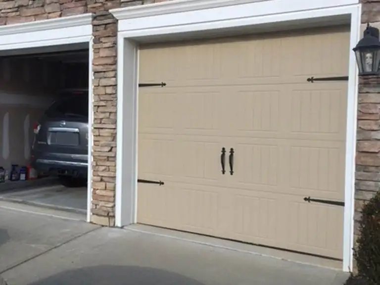 The same garage rebuilt, with a new door, stone surround and clean trim